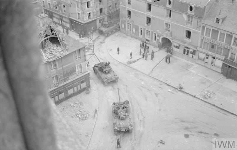 sherman tanks passing though la delivrande towards caen 46 commandos and graves of 46 commando 4 th s s bde taken by lt handford 8 june 1944 iwm b 5268